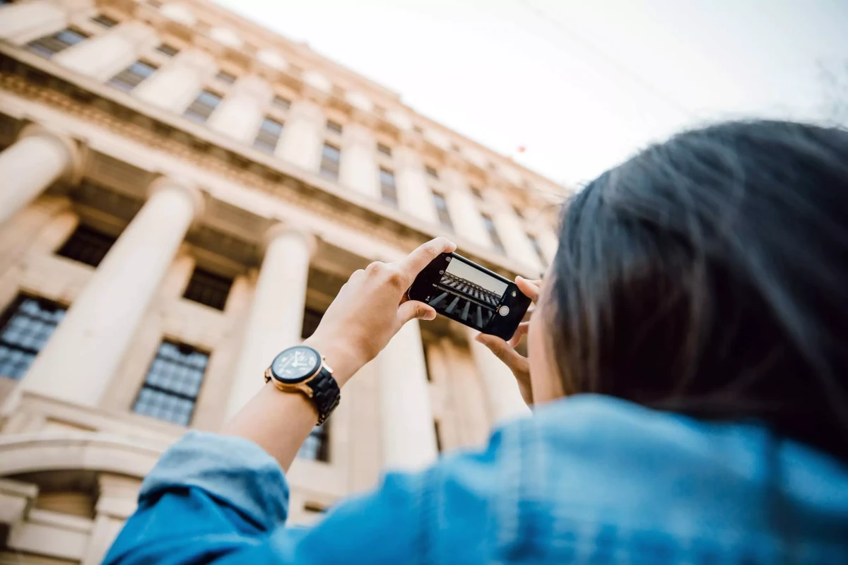 Turista tirando unha foto dun edificio.